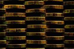 Stacks of coins closeup. Money textured background. Dark brown business wallpaper made of many coin edges. Image with high contrast and saturation. Economy finance and banking. Macro