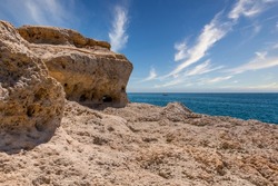 Beautiful coast line and sunny beaches in the portuguese region of Algarve. Natural caves at Carvoeiro beach, Algarve Portugal. Rock cliff arches and turquoise sea water