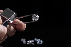 Gem stones. Jeweller checking polished diamond. Carat size diamonds. Diamond trading and dealing. Loose diamond grading. Precious stones.