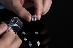 Jeweller checking diamond. Loose diamonds. Cut and polished diamonds. Hand with diamond. Diamond expert examining diamonds.