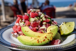 Tuna Ceviche Tostada served with avocado and lime on the beach in Mexico