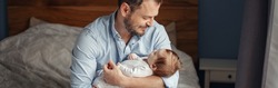 Fathers Day. Middle age Caucasian father with sleeping newborn baby girl. Parent holding child on arms. Authentic lifestyle parenting moment. Single dad family. Web banner header.