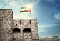 National flag of UAE flying on an old, heritage Arabic building. Beautiful photo background with flag for 2nd December celebration in UAE.