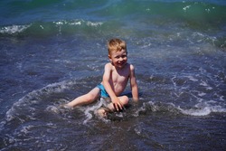 Ureki, Georgia - July 8, 2021: Boy swims in the sea