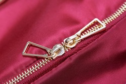 Golden zipper close up view. Buttoned metal zipper on backpack or clothes.