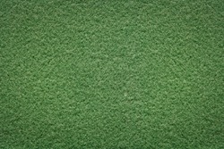 Green background of softness felted wool. Textured fluffy wool fabric. Warm fabric with short pile for outerwear. Closeup top view.