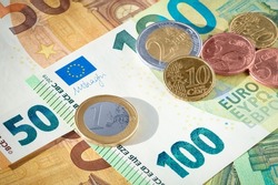 EU euro coins on heap of euro bills. EU economy and finance. Cash money. Currency background. Close up view.