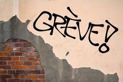 French text Greve (strike) - Handwritten graffiti sprayed on the wall, anarchist aesthetics. Appeal to fight for good conditions for employees at work. Uprising against exploitation