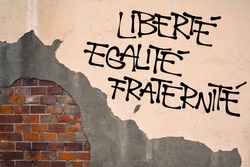 French text Liberte, Egalite, Fraternite ( Liberty, Equality, Fraternity ) - Handwritten graffiti on the wall, anarchist aesthetics. Revolutionist motto. Appeal to fight for republic and constitution
