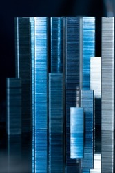 Abstract high rise buildings made from stack of metal staples for stapler on a black background