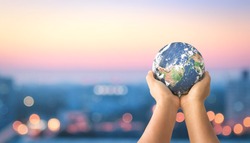 Donation for Covid 19 concept:  Human hands holding earth global over blurred city night background. Elements of this image furnished by NASA