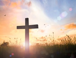 Good Friday concept: Silhouette cross of Jesus Christ on meadow autumn sunrise background
