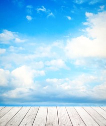 Blue sky and white clouds with pale wooden floor background