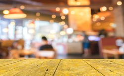 wood table and Coffee shop blur background with bokeh image.