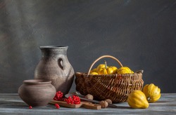Still life in a rustic style: autumn harvest. Pumpkins and red berries on a wooden table. Natural light from a window.