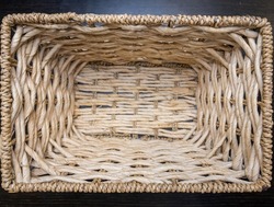 Rustic background from natural material. Texture of a wicker basket close-up. Straw weaving craft. Vintage background basket