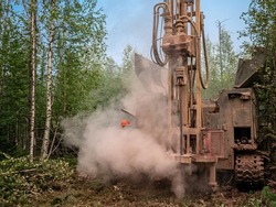 Crawler drilling rig drills a well, a lot of dust when drilling a borehole.