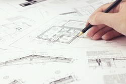 An architect engineer creates a working drawing sketch for building a house building. Architectural design projects concept. Engineering and architecture drawings