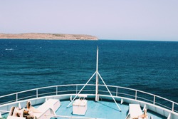 Boat view on the blue see and land on the horizon - Malta