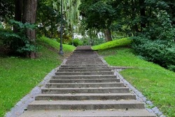 Concrete stairs surrounded by green grass and trees in the Royal Bath Park, Lazienki, in Warsaw, Poland. Selected focus.