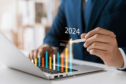 Businessman analyzes profitability of working companies with digital augmented reality graphics, positive indicators in 2024, businessman calculates financial data for long-term investments.