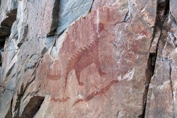 An ancient Indigenous pictograph is painted on a rock face on a cliff at the side of Lake Superior in the provincial park.