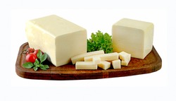 Block of mozzarella cheese and pieces on wooden board. 