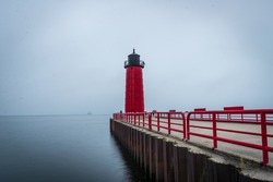 Red Lighthouse on Lake Michigan in the early morning hours of a foggy day