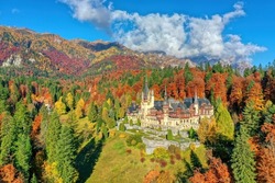Peles Castle, Sinaia, Prahova County, Romania: Drone view of famous Neo-Renaissance castle in autumn colours, at the base of the Carpathian Mountains, Europe