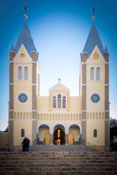 Portrait Front View - Saint Mary's Peach Coloured/Colored Twin Tower Cathedral With Open Door, Against A Clear Blue Namibian Sky, With Brown Stairs - Roman Catholic Church City Center Windhoek Namibia