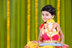 Little Indian girl child with lord ganesha and praying , Indian ganesh festival