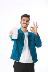 Young indian man showing smartphone screen on white background.