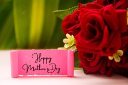 Happy mother's day text on torn pink paper with roses and plant background. Mother's day concept