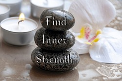 Find inner strength text engraved on black zen stones. Motivational concept.