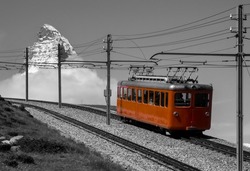 Famous narrow gauge gear train “Gornergrat-Bahn“ climbing up to mountain station with panoramic viewpoint near Zermatt Switzerland. Historic railcar near Riffelalp (2006) with iconic Matterhorn peak.
