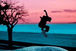 silhouette skateboarder jumping in a skatepark