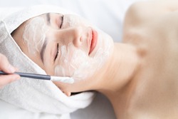 Asian woman doing beauty treatments, spa treatments and being applied cream to her face