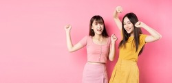 Two young Asian women on pink background