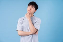 Young Asian man posing on blue background