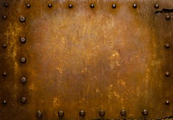 Rusted metal wall plate with three borders of metal studs, showing orange and brown scratch and scuff marks.  Suitable for wallpaper or background or grunge texture.