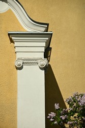 a fragment of the façade of a historic building painted in yellow and white