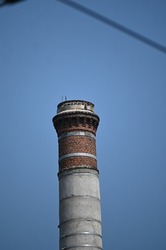 tall round brick chimney against sky background