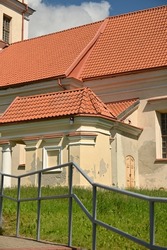 a fragment of the facade of a historical building with a red clay tile roof