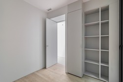 Interior of gray room with wardrobe and empty shelves. Refurbished apartment before settling of new tenants