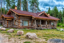 a wooden log cabin in pine forest in summer