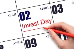 2nd day of April. Hand drawing red line and writing the text Invest Day on calendar date April 2. Business and financial concept. Spring month, day of the year concept.
