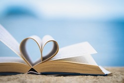 The heart shape from the book against the blurred sea background Love concept