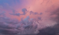 Dramatic sky and a view of infinity. Clouds in sunset, place for copy space. Look up to the sky, amazing desktop wallpaper. Purple pink illuminated clouds in the evening heaven. After the storm
