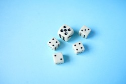 White dices on 
blue background.The Dice game is one of the oldest of all the games in the world and. It can play by all of ages of player. Top view of dices.