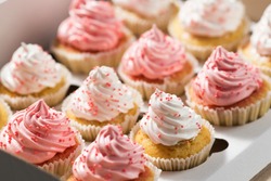 Cupcake packaging, delivery box, vanilla cupcakes with pink and white cream, selective focus, close up